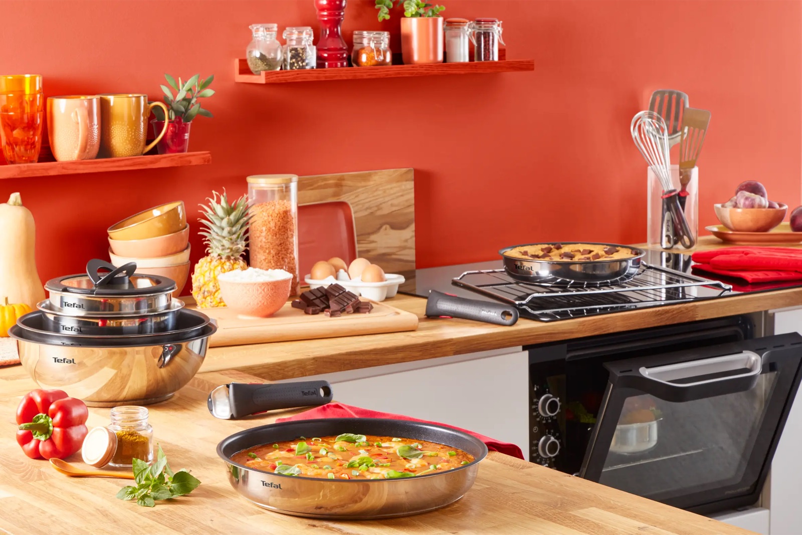 Cocina con el set Ingenio Emotion: sartén en la encimera, cacerolas apiladas y molde en el horno